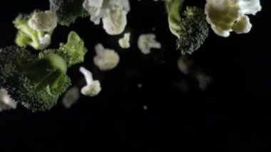 Karnabahar havada bir siyah arka plan üzerine düşüyor. ağır çekim.