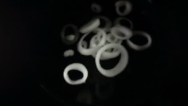 Plasterki cebuli spadające na białym na czarnym tle — Wideo stockowe