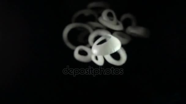 Sliced falling onion isolated on a black background — Stock Video