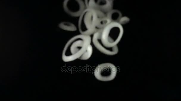 Sliced falling onion isolated on a black background — Stock Video