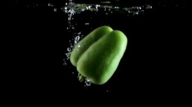 Siyah arka plan üzerine su taze yeşil biber sıçrama