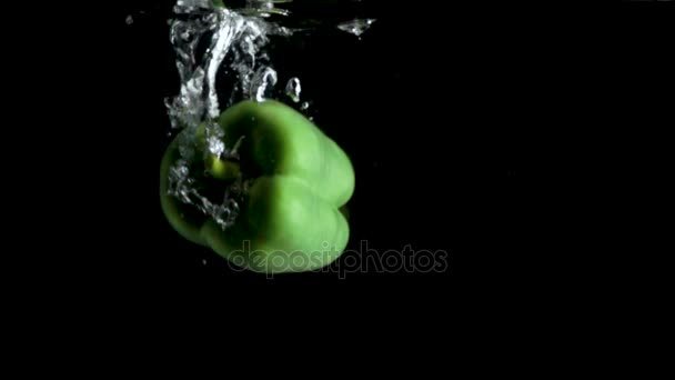 Φρέσκο πράσινο πάπρικα βουτιά στο νερό σε μαύρο φόντο — Αρχείο Βίντεο