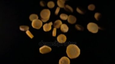 siyah bir zemin üzerine düşen havuç dilimleri. Makro