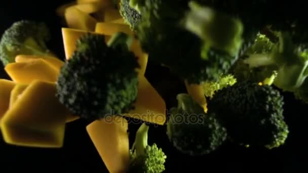 A piece of pumpkin with broccoli isolated on a black background top view. Slow motion — Stock Video