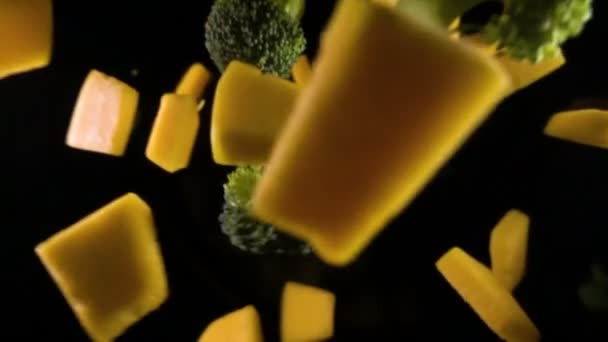 A piece of pumpkin with broccoli isolated on a black background top view. Slow motion — Stock Video