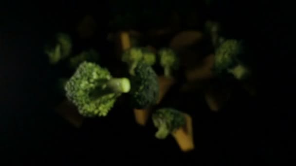 Ein Stück Kürbis mit Brokkoli isoliert auf einem schwarzen Hintergrund Draufsicht. Zeitlupe — Stockvideo