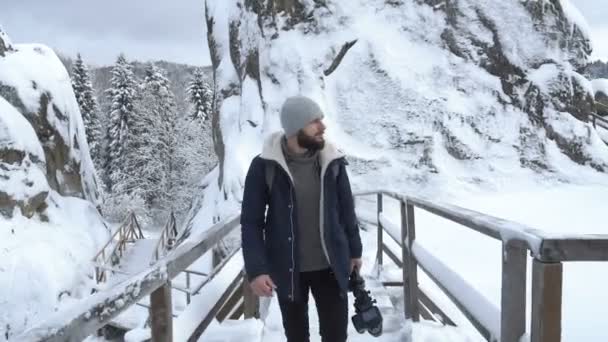 Фотограф снимает заснеженные горы — стоковое видео