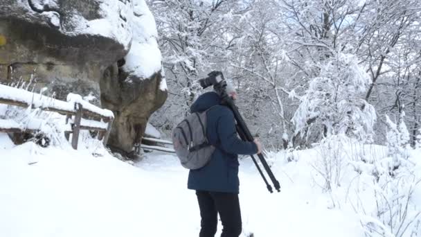 Profesjonalny fotograf z plecakiem idzie do lasu iglastego po burzy śnieżnej, zimowe przygody. — Wideo stockowe