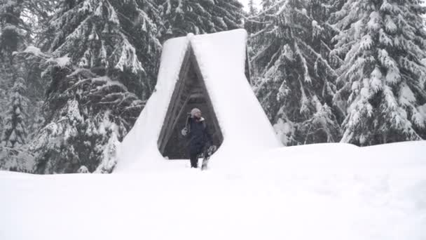 Профессиональный фотограф с рюкзаком отправляется в хвойный лес после снежной бури, зимних приключений . — стоковое видео