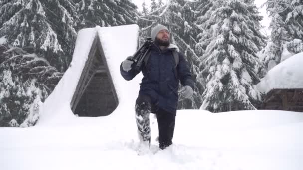 Fotógrafo profesional con una mochila va al bosque de coníferas después de una tormenta de nieve, aventuras de invierno . — Vídeo de stock