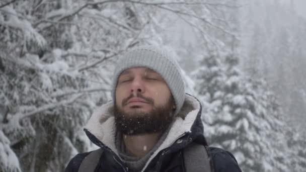 Ritratto di giovane barbuto allegro e bello in piedi nella foresta invernale. Rallentatore — Video Stock