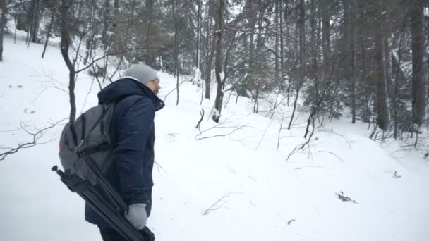 Fotógrafo de paisagem profissional caminhando pela floresta de abetos no inverno. câmara lenta — Vídeo de Stock