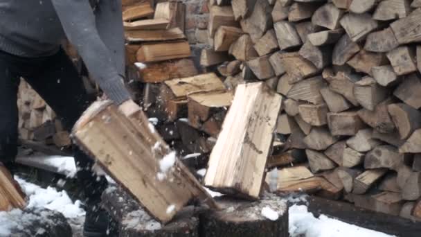 Медленное движение красивого молодого человека рубить лес с топором рядом с домом зимой — стоковое видео