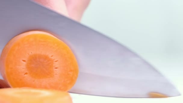 Mujeres manos cortando zanahoria, detrás de verduras frescas . — Vídeo de stock