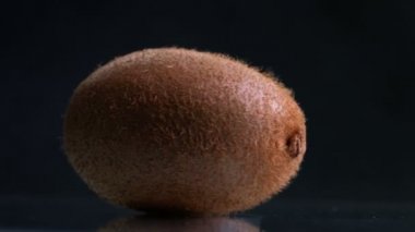 Siyah arka plan üzerine dönen kivi