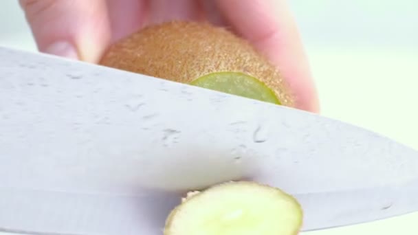 Kiwi wordt gesneden in de helft op natte witte achtergrond. Close-up — Stockvideo