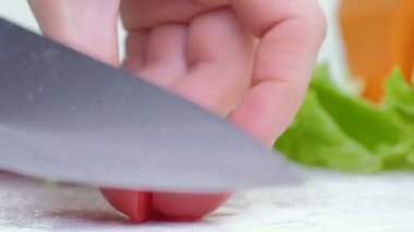 Beyaz tahta, beyaz arka plan üzerinde mutfak bıçak ile kesme kırmızı kiraz domates kapatın görüntüleri 4k