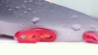 Kesme tahtası ve bıçak beyaz zemin üzerine kırmızı biber.