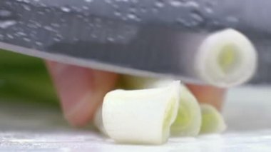Yeşil soğan tahtada bir bıçakla kesilmiş. Kesme yeşil çerçeve elinde olmadan. Chef malzemeler çorba için keser. Yakın çekim