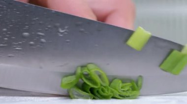 Yeşil soğan tahtada bir bıçakla kesilmiş. Kesme yeşil çerçeve elinde olmadan. Chef malzemeler çorba için keser. Yakın çekim