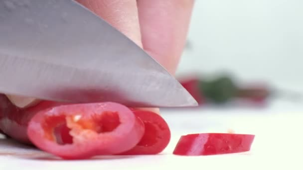 Pimientos rojos sobre tabla de cortar y cuchillo sobre fondo blanco . — Vídeos de Stock