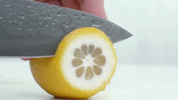 Faca um limão suculento de corte em um fundo branco . — Vídeo de Stock