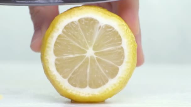 Knife a cutting juicy lemon on a white background. — Stock Video