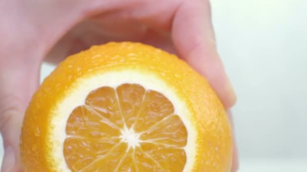 Corte de naranja sobre tabla de cortar primer plano sobre fondo blanco — Vídeos de Stock