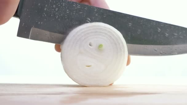 Rodajas de cebolla y cebolla sobre tabla de cortar de madera . — Vídeo de stock