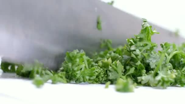 Cooks hands cutting parsley on white cutting board — Stock Video