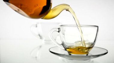 Dökme çay. Çay cam şeffaf çay fincan içine dökülür varlık. Çay saati. Şeffaf cam çaydanlık ve çay fincanı. Ağır çekim