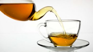 Dökme çay. Çay cam şeffaf çay fincan içine dökülür varlık. Çay saati. Şeffaf cam çaydanlık ve çay fincanı. Ağır çekim