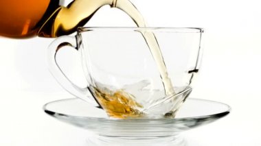 Dökme çay. Çay cam şeffaf çay fincan içine dökülür varlık. Çay saati. Şeffaf cam çaydanlık ve çay fincanı. Ağır çekim