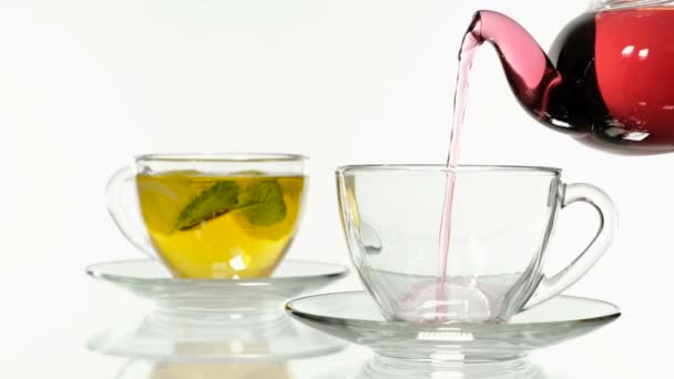 Het maken van hibiscus thee in een glas van een kopje thee. Witte achtergrond — Stockvideo