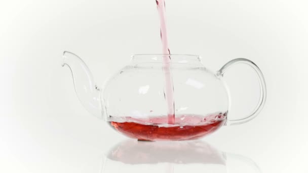 Tisane fraîche dans une théière en verre et une tasse, thé rose .