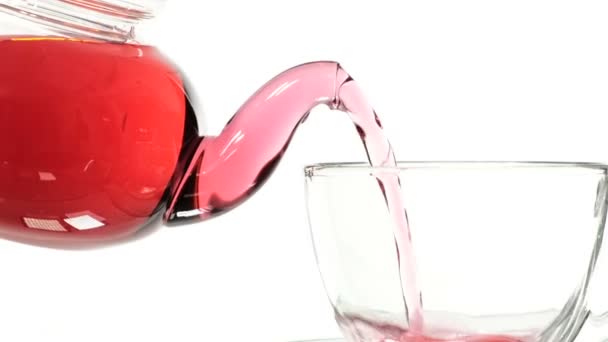 玻璃茶壶中的红玫瑰茶和白色背景的杯子. — 图库视频影像