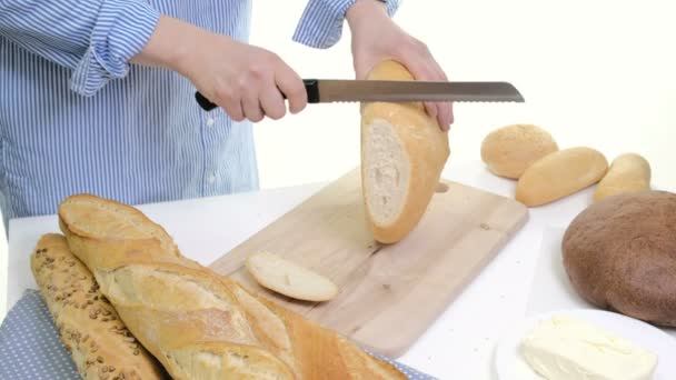 Rebanada de pan fresco y cuchillo de corte en mesa rústica. Con las manos de lana — Vídeos de Stock