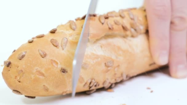Cortar de cerca el pan crujiente fresco. Panadero tallar pan de tachuela suave caliente con cuchillo grande en la mesa de la cocina . — Vídeos de Stock