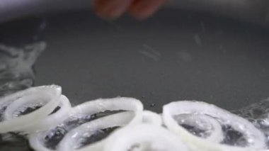 Doğranmış soğan sebze yağı tavada kızarmış. Bir mutfak döşeme üstüne yakın çekim. Kızgın tavada kavurma.