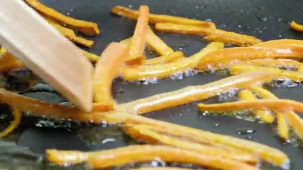 Close-up cenouras fritas no painel de fritamento.Um close-up de legumes em uma frigideira. Cenoura de laranja perto em uma panela de ato de fritar . — Vídeo de Stock