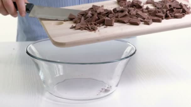 Cucinare mani tagliando barretta di cioccolato con un coltello da cucina sul tagliere . — Video Stock