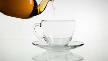 Dökme çay. Çay cam şeffaf çay fincan içine dökülür varlık. Çay saati. Şeffaf cam çaydanlık ve çay fincanı. Ağır çekim