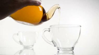 Dökme çay. Çay cam şeffaf çay fincan içine dökülür varlık. Çay saati. Şeffaf cam çaydanlık ve çay fincanı. Ağır çekim