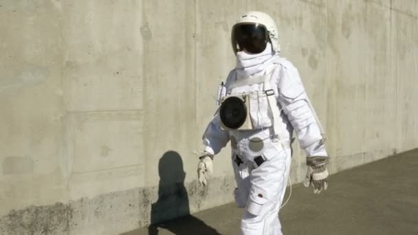 Az űrhajós sétálhat a város. Egy szokatlan jelenet a város. — Stock videók