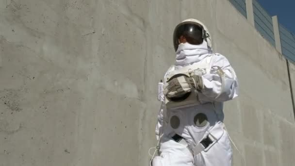 Космонавт гуляет по городу. Необычная сцена из города . — стоковое видео