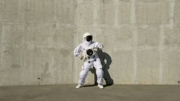 有趣的宇航员会跳舞。在混凝土墙的背景下. — 图库视频影像