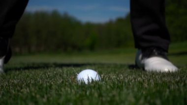 Golf Kulübü ağır çekimde yeşil suni çim üzerinde topa vuruyor