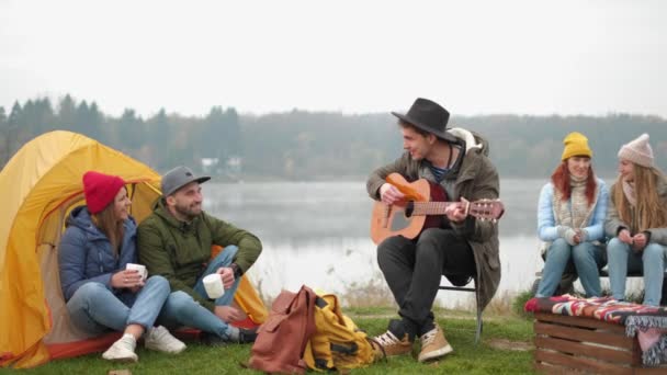 Skupina přátel kempovala, seděli u ohně a hráli na kytaru. — Stock video