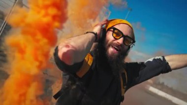 Sarı gözlüklü bir hippinin portresi. Portakal dumanıyla dans eden sokak dansı. Yavaş çekim