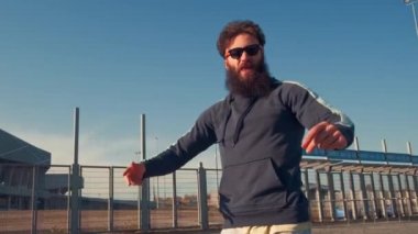 Hippi Erkek, sokakta dans ediyor ve kameraya bakıyor.,